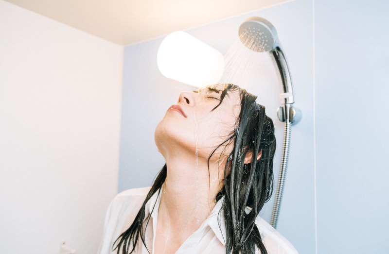 シャワーで水を浴びる女性